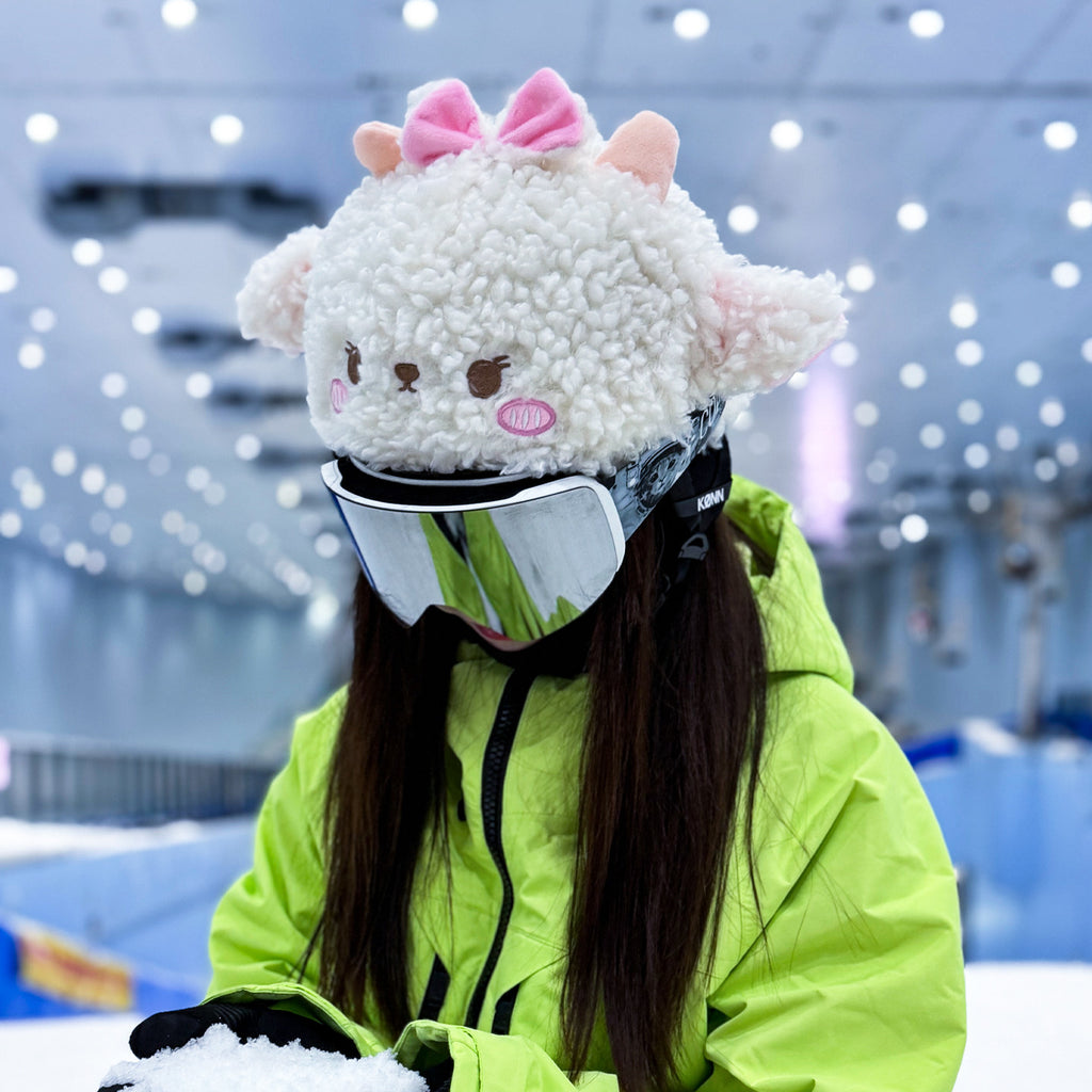Person wearing a fluffy animal-themed helmet and green jacket in an indoor setting.
