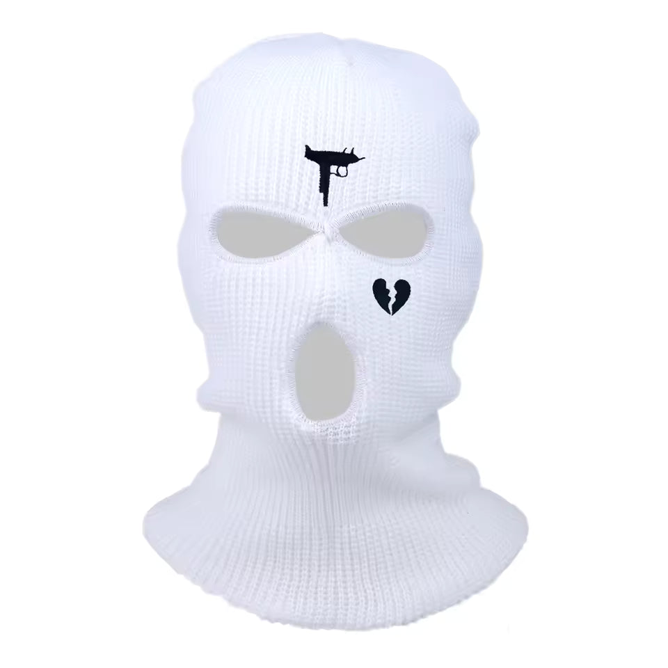 White knit balaclava with face holes and black designs on a white background