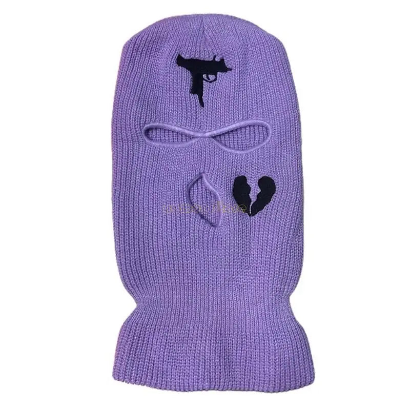 Purple knitted balaclava with black embroidered designs on a white background