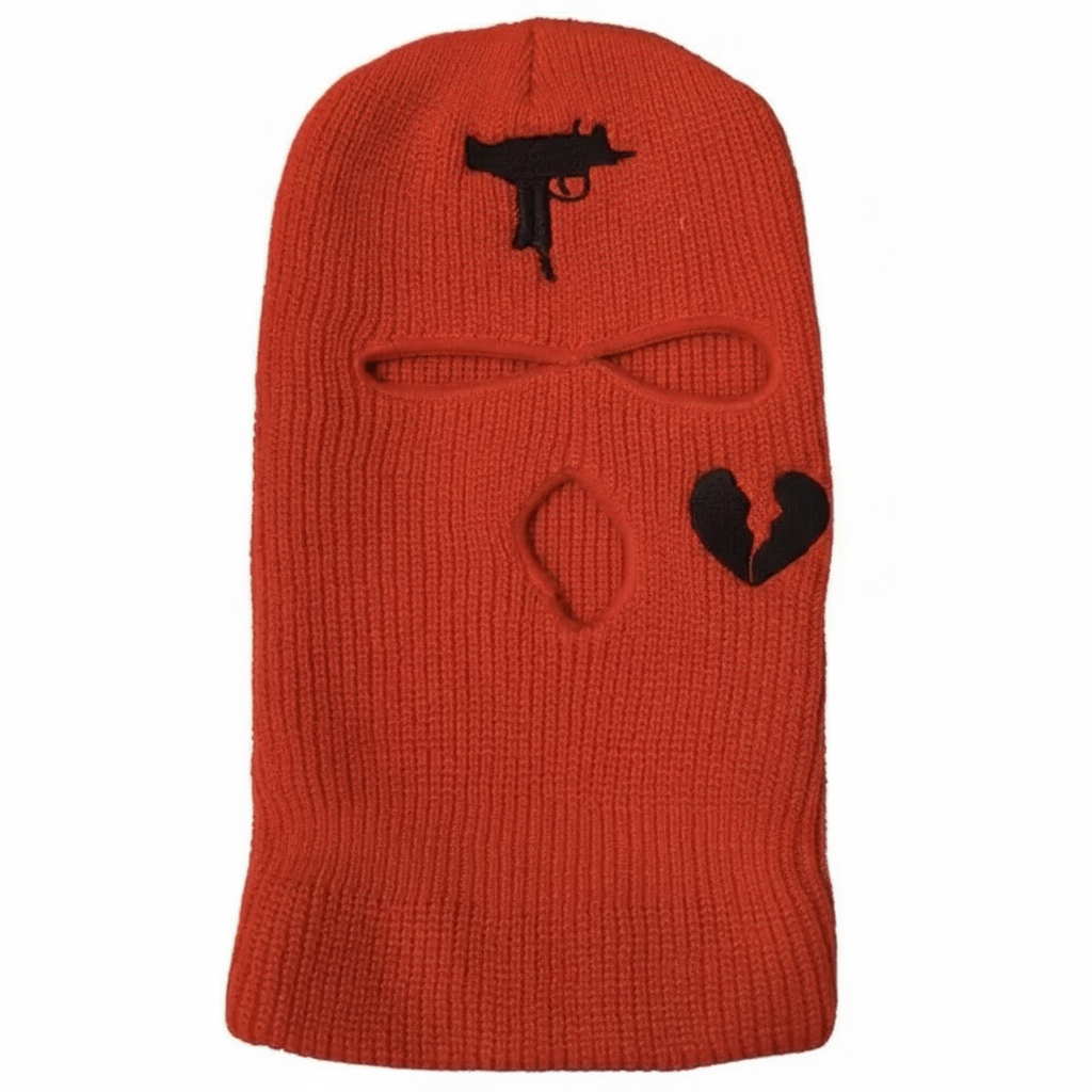 Orange knit balaclava with black gun and heart designs on a white background